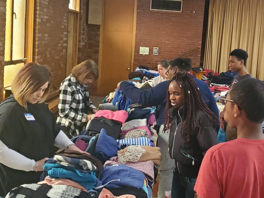 Volunteers assist event attendees select clothing at BWEL's Giveaway Event